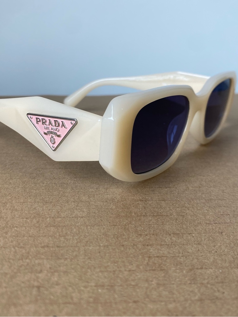 Prada Kids Cream Frame Sunglasses with Pink Triangle Logo and Dark Lenses